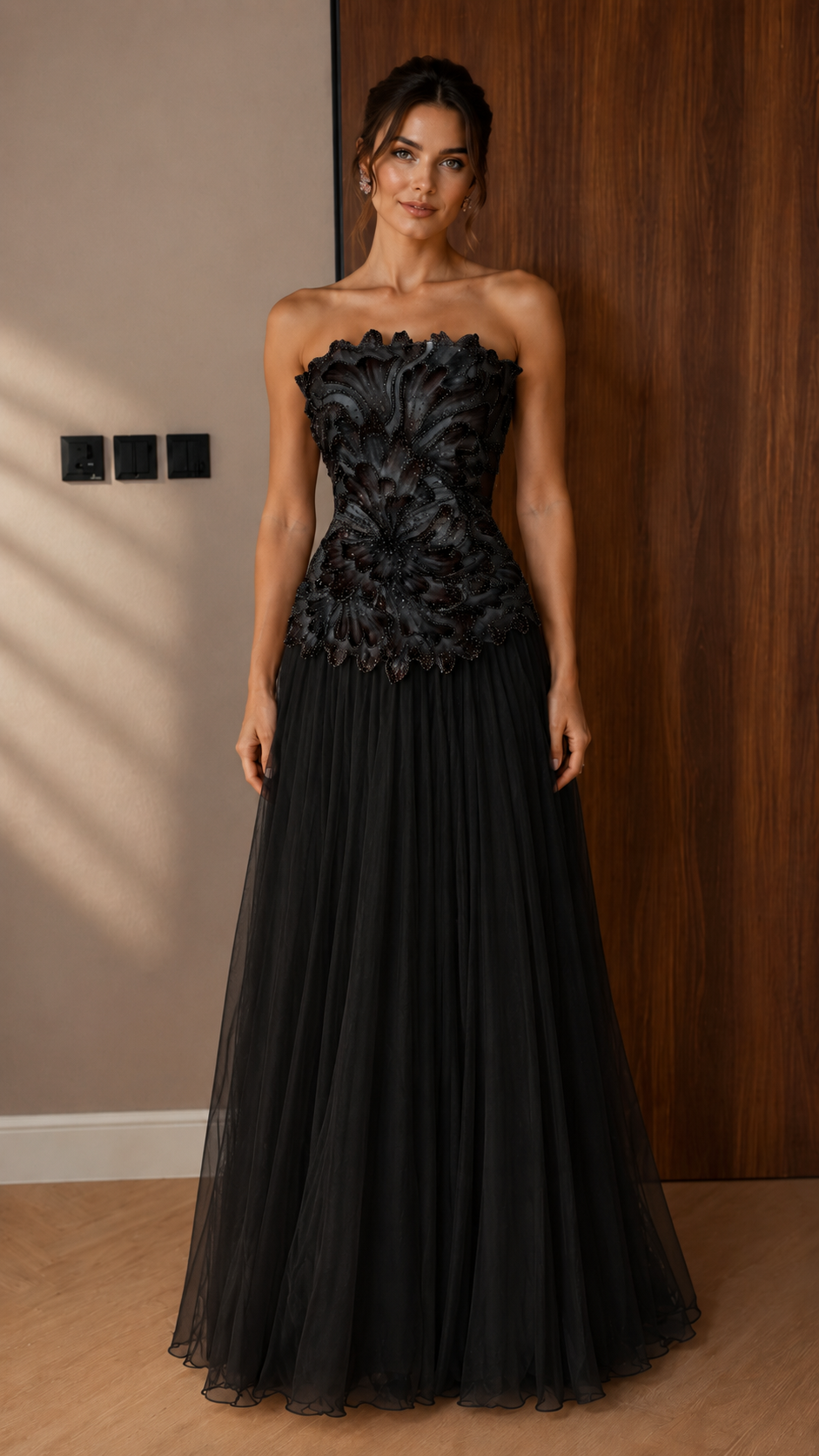 Front view of black strapless appliqu¨¦ evening gown with pleated floor-length skirt