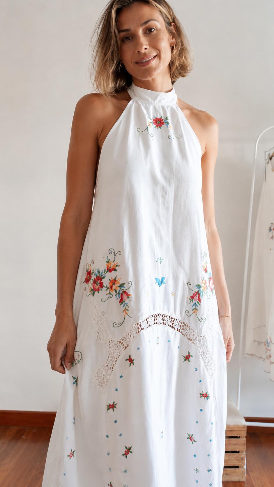 Close-up front detail of white embroidered halter maxi dress