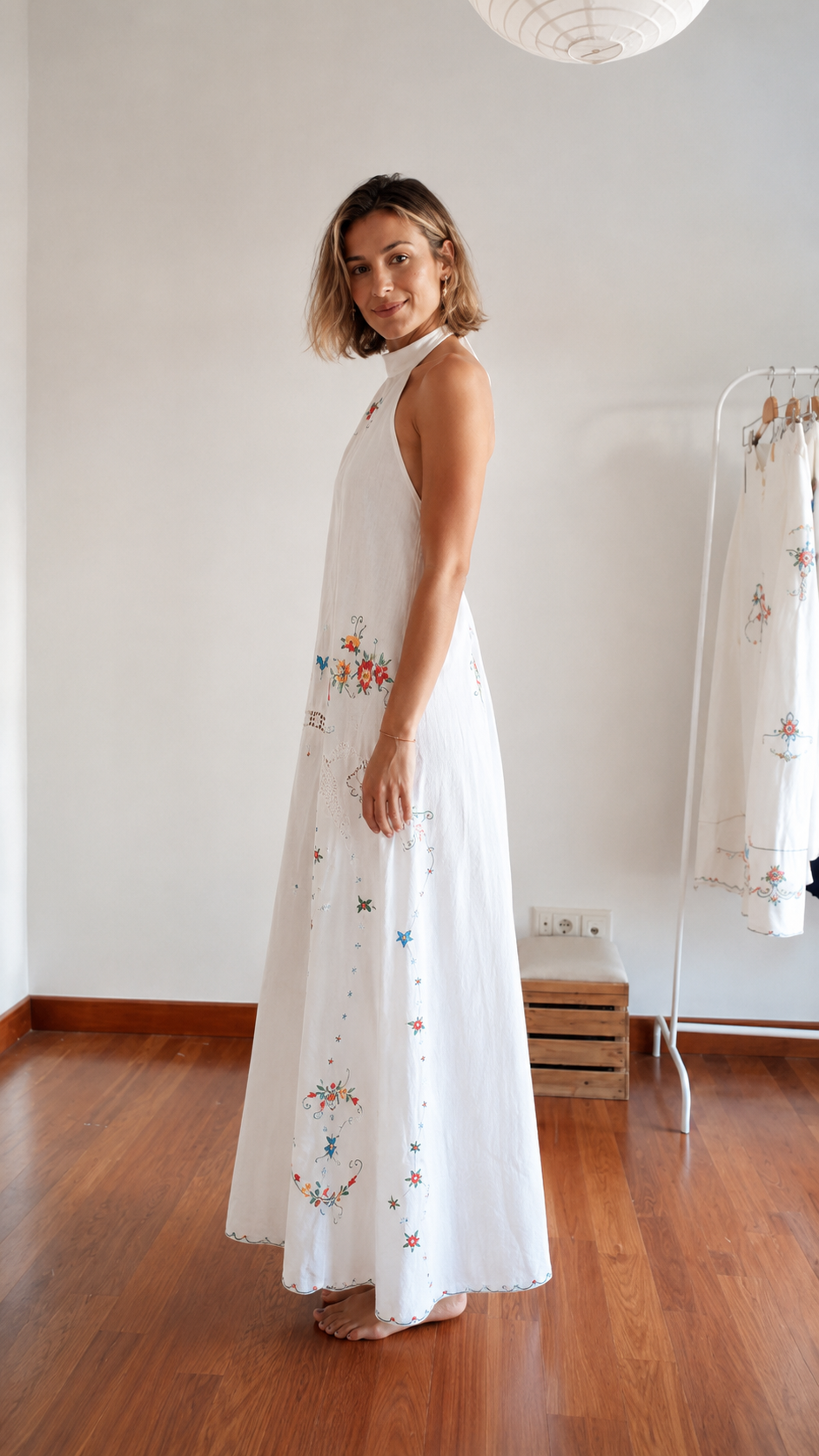Side view of white embroidered halter maxi dress